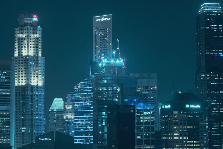 A skyscraper is constructed over time in a metropolis at night