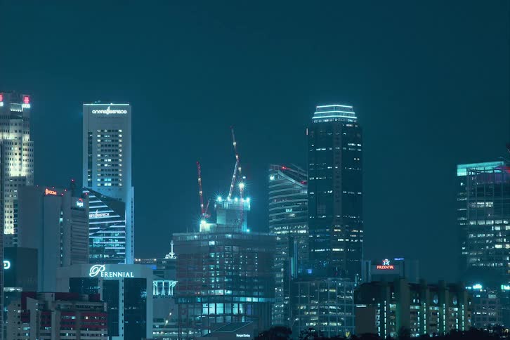 Time lapse of lights flashing on office buildings and a high rise being built in a downtown area