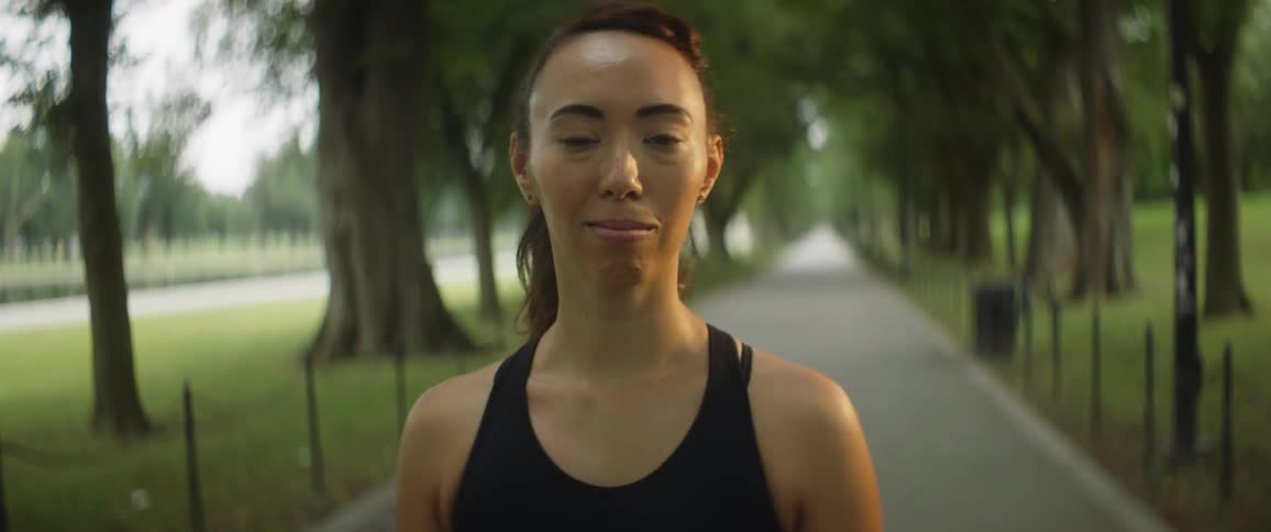 A woman is smiling in the park