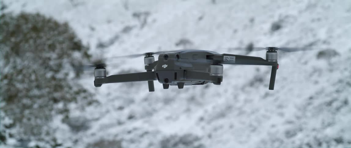 Aerial drone flies over snowy ground