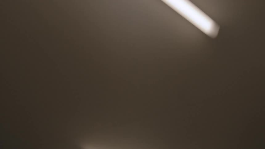 Long ceiling lights sit jagged on the ceiling of a hallway