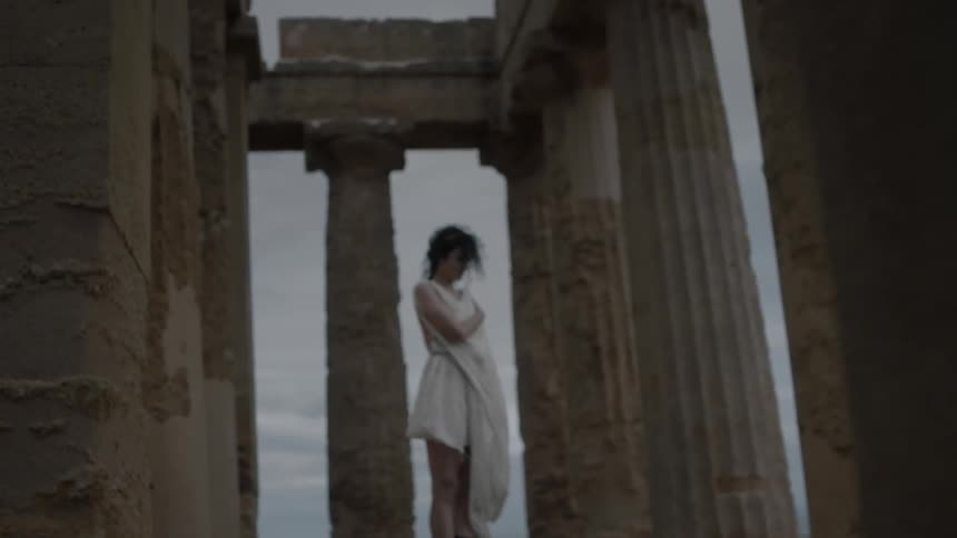 A woman standing in the acropolis on a cloudy day
