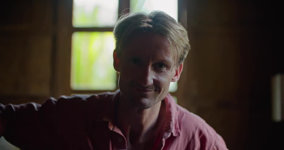 A man smiles and looks to the side