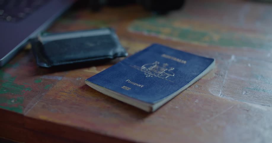A passport and wallet on a wooden table