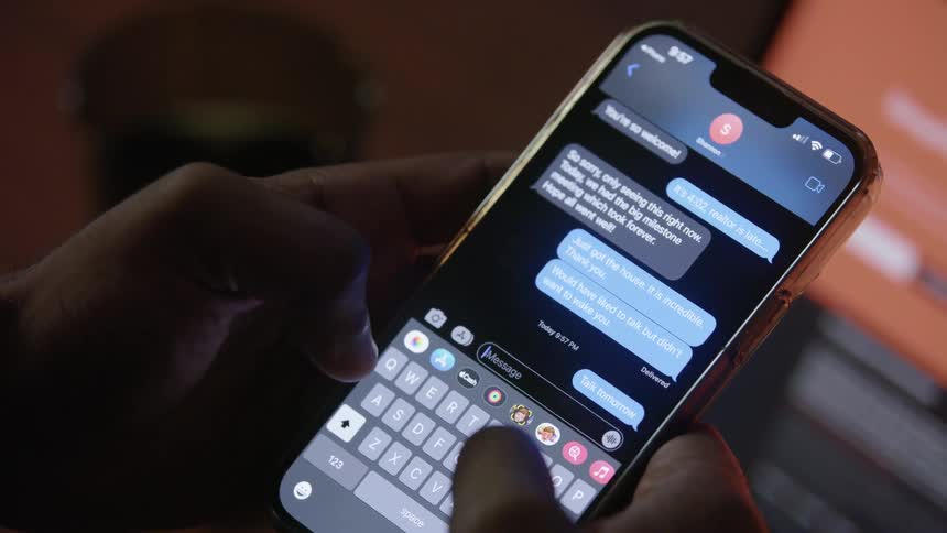 A man sends a text message before putting his phone on his desk
