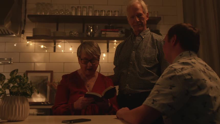 A woman is reading to two men