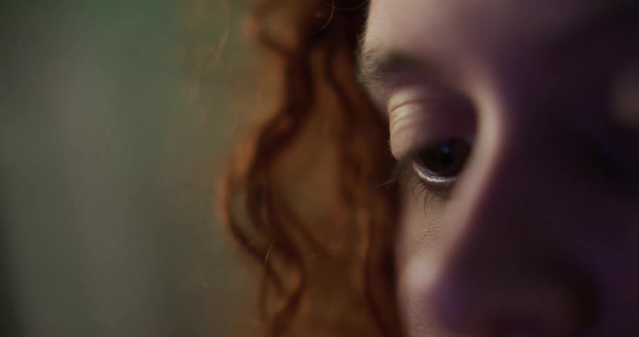 Close up of woman with brown wavy hair reading book