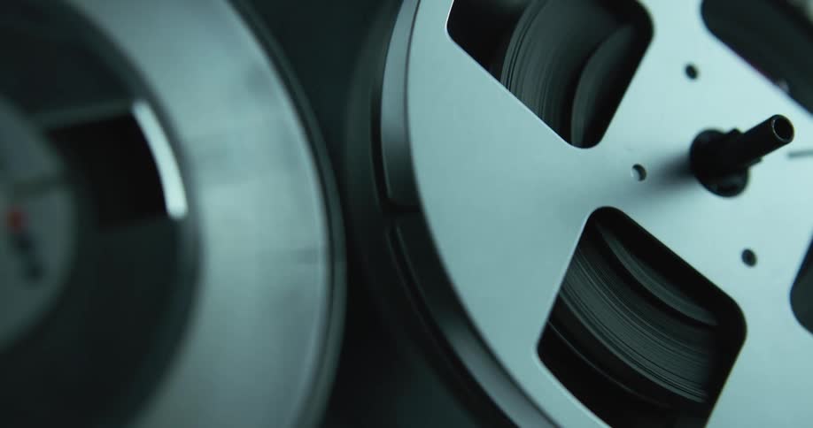 Close up of rolls of tape slowly turning on a vintage tape recorder