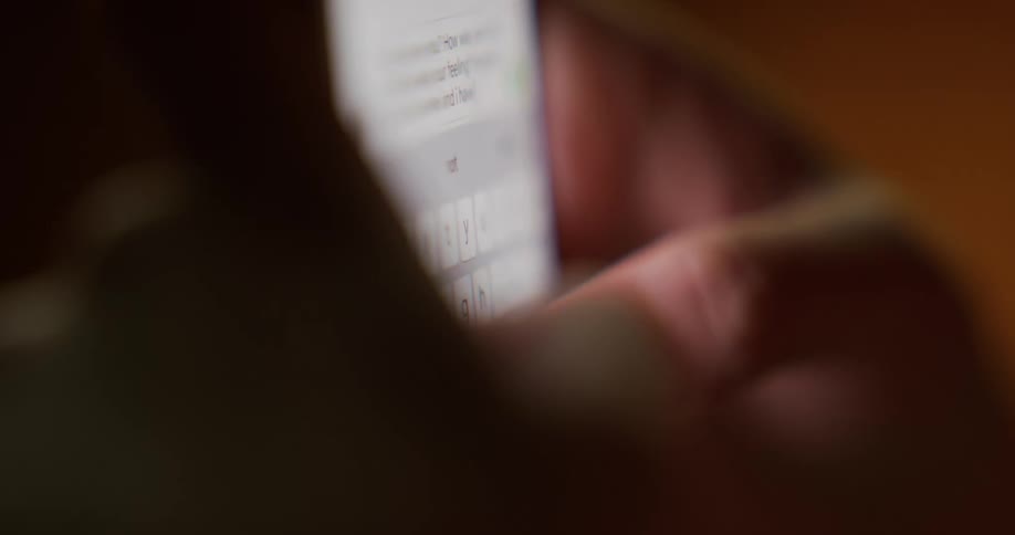 Close up of the hands of a man texting on his smartphone