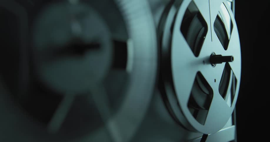 Close up of rolls of tape slowly turning on a vintage tape recorder