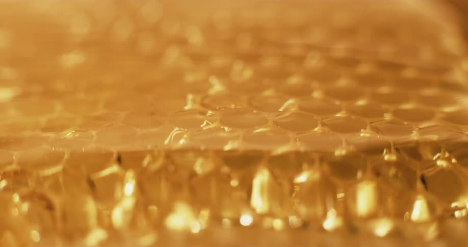 Golden honey flowing over honeycomb