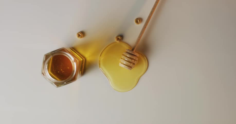 Honey puddles around wood utensil near cereal holes