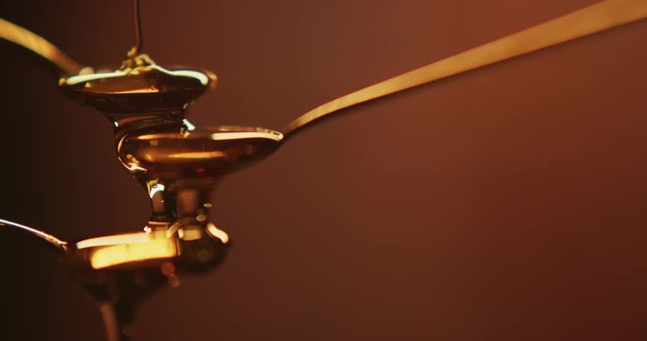 Amber honey flows through series of funnels and tubes