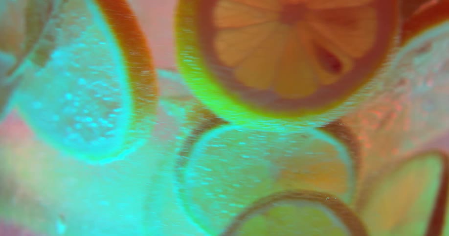 Lemon slices and mint leaves spin around in a pitcher of water