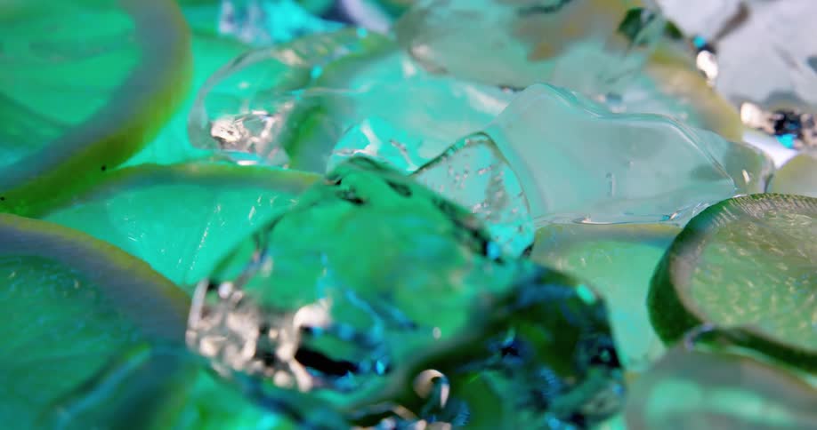 Lemon or lime slices and ice cubes floating on the surface of a drink
