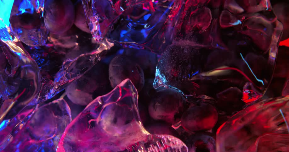 Blueberries sit under a pile of ice in water