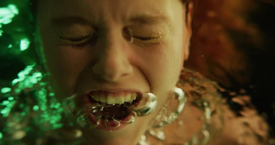 Woman puts her face into water and yells creating a flow of bubbles