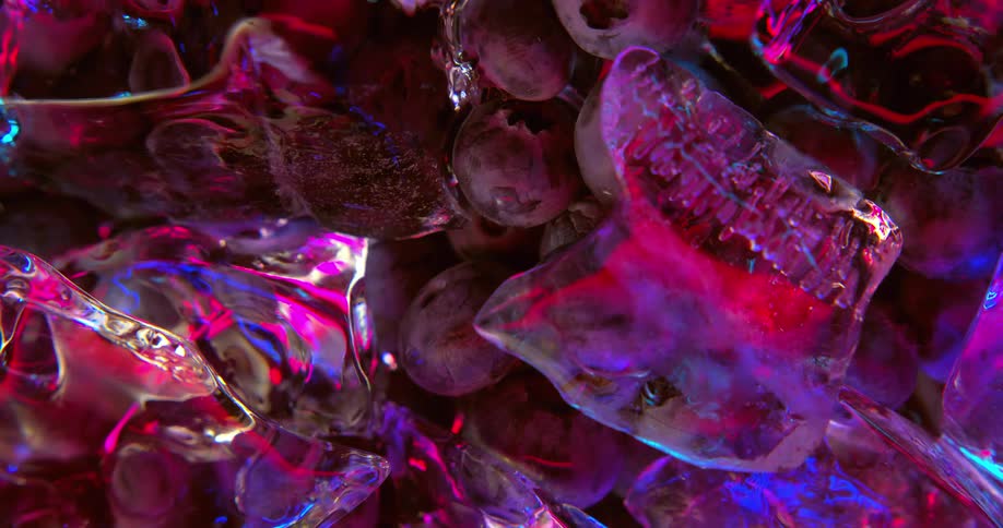 Blueberries sit under a pile of ice in water