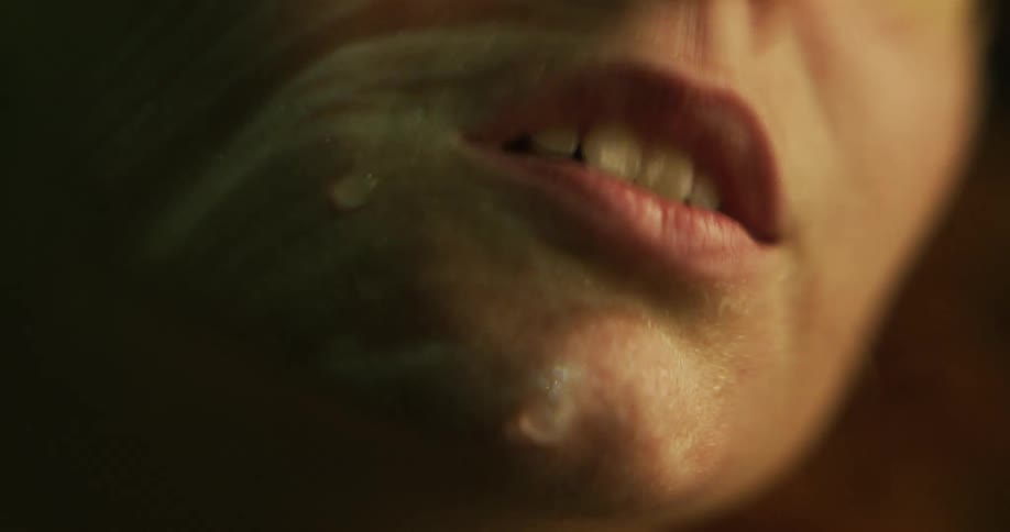 Small waves ripple over a womans face as she lies partially underwater