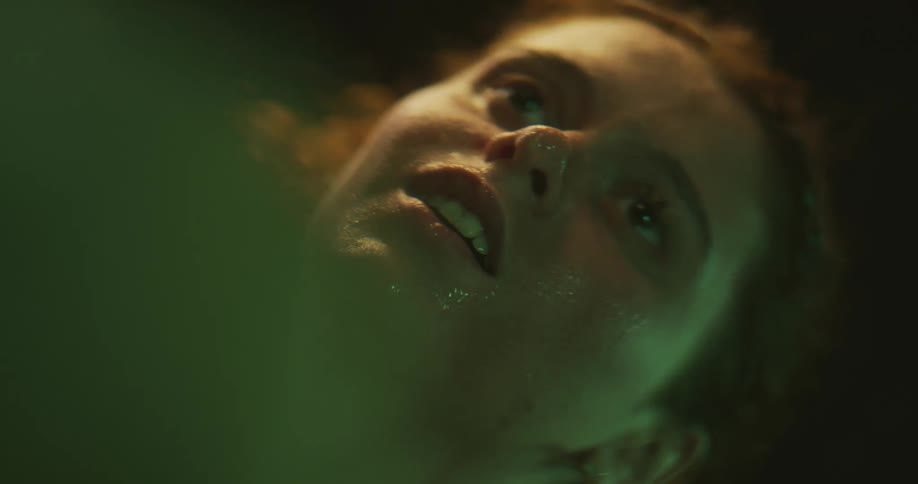 Close up of the face of a wet woman dripping water over the surface