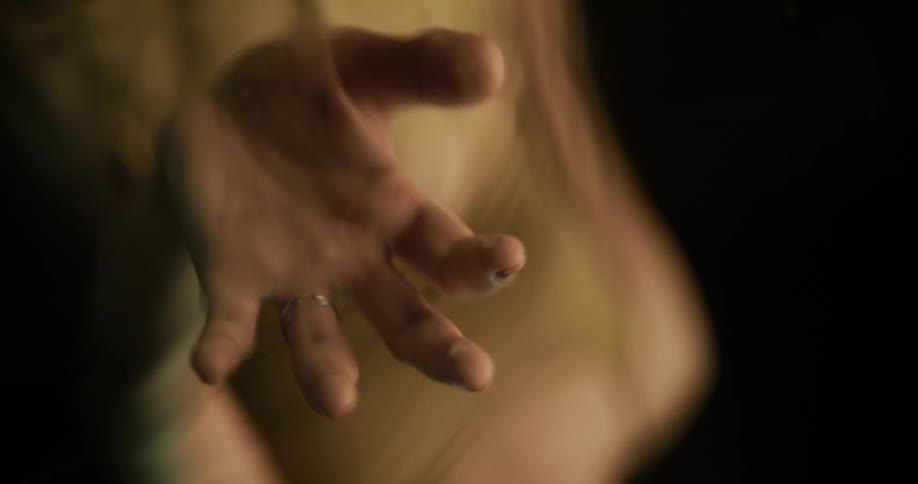 A woman runs her hands through bath water