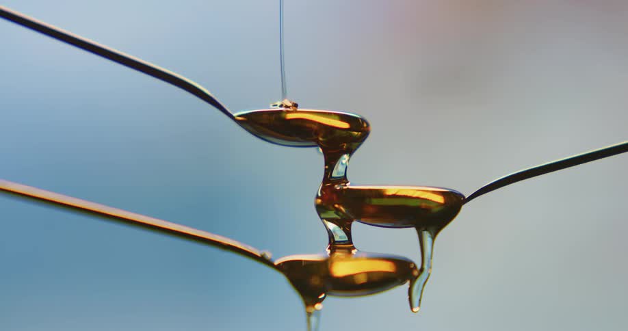 Three spoons form tiers for honey to flow down
