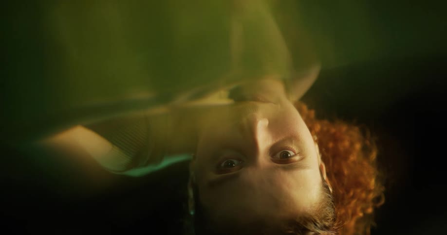 A woman floats upside down in a pool