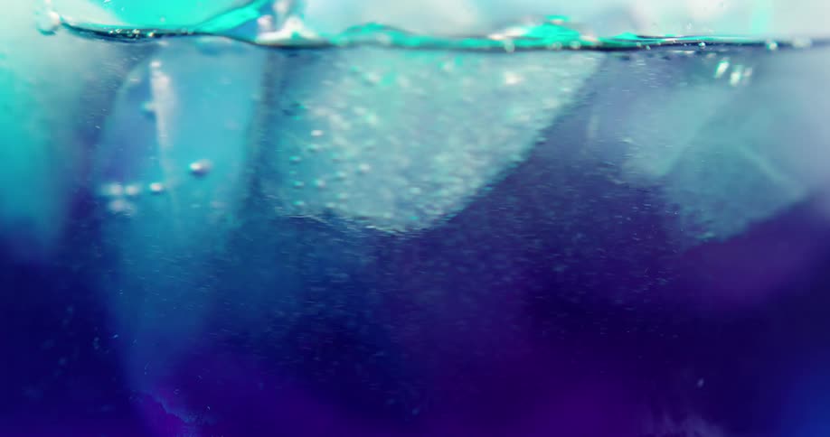 Ice cubes floating in a carbonated beverage