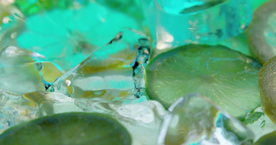 Lemon and lime slices surrounded by ice floating on the surface of a drink
