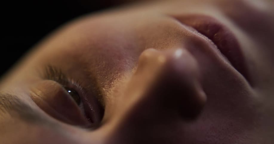 Close up of the face of a young woman laying on the floor