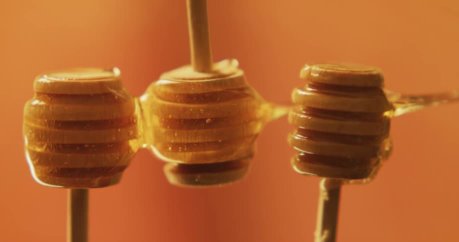Honey flowing over honey sticks set up for a photo shoot