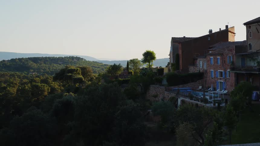 Houses on a small town surrounded by lush vegetation on the hills at morning