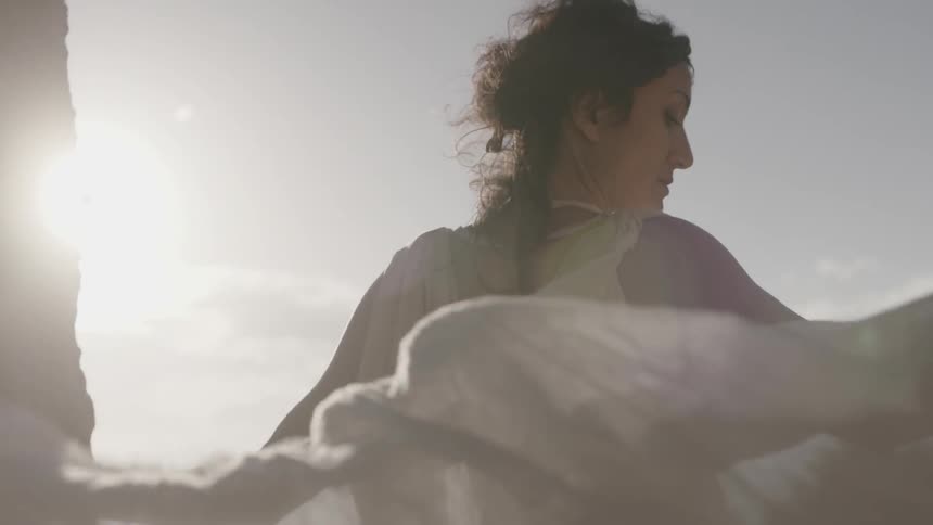 A woman's gauze dress train billowing in the wind