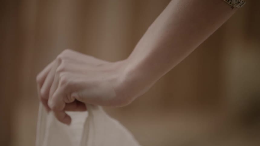 A woman's hand holding white cloth