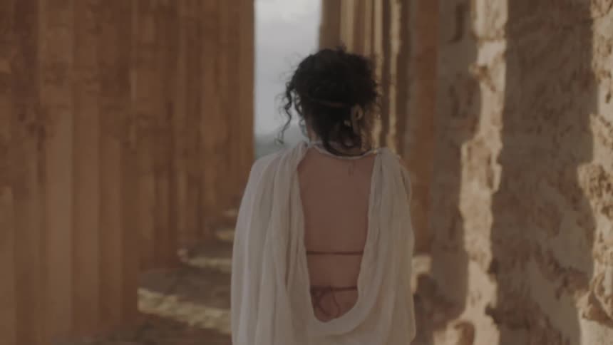 A woman walking between the acropolis' columns