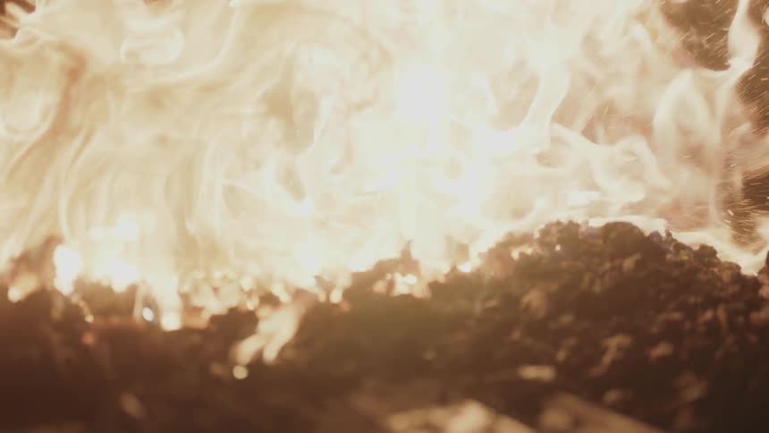 A man is stirring coals in a fire
