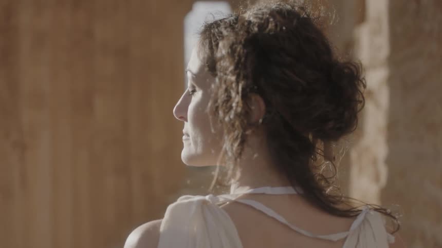 A woman looks to the side with her eyes closed