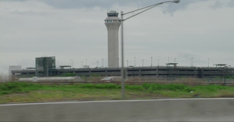Traffic moves along highway near airport control tower