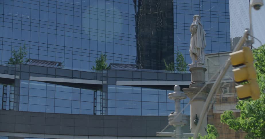 A statue sits at an intersection filled with tall skyscrapers