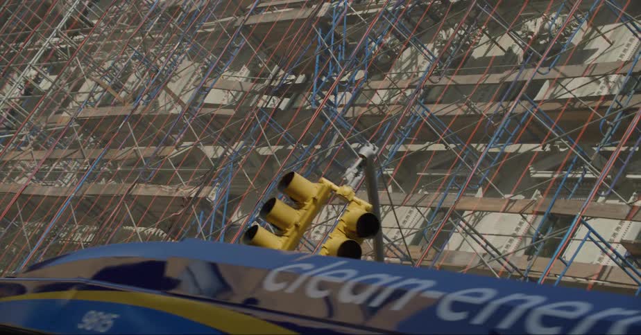 A vehicle driving by a building under construction