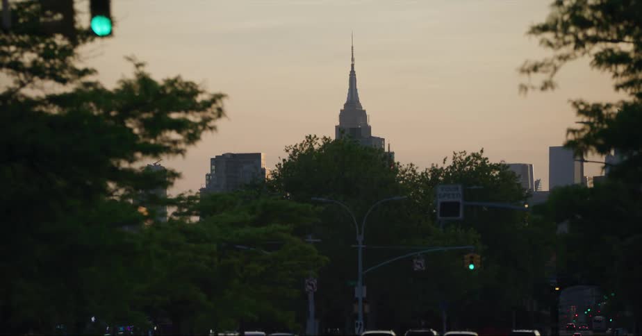 Distant skyscraper and high rise buildings seen from vehicle driving on highway in the city