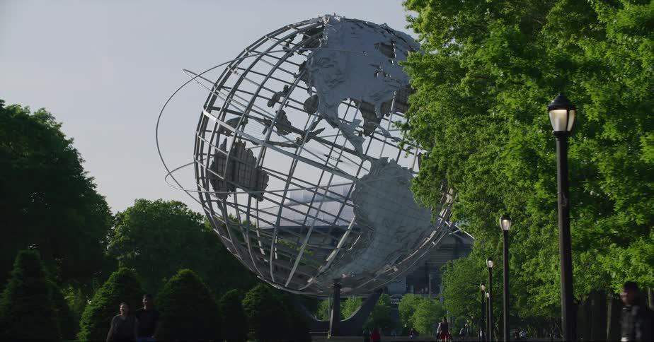 People walk near the steel globe sculpture at columbus circle in new york city