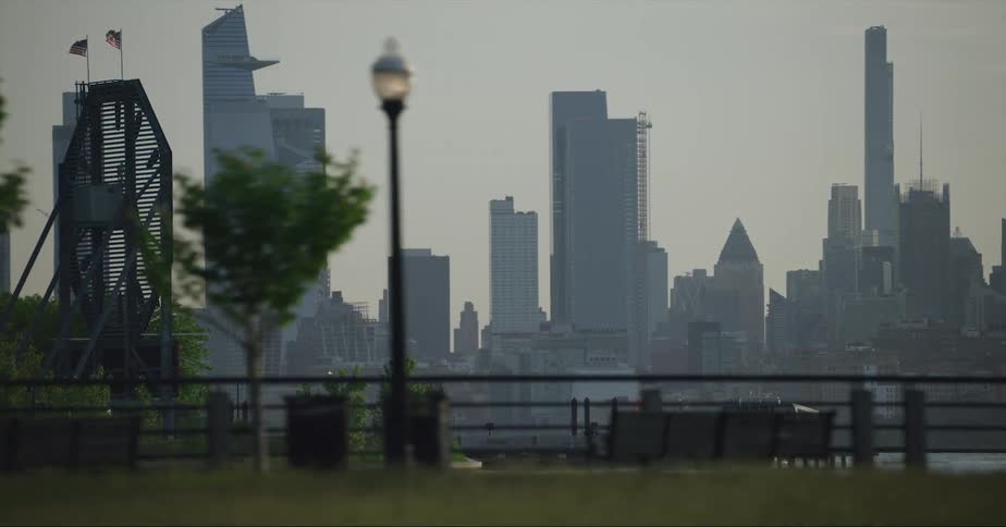 Moving across the harbor coast as a boat sails tall buildings and skyscrapers are on the city skyline