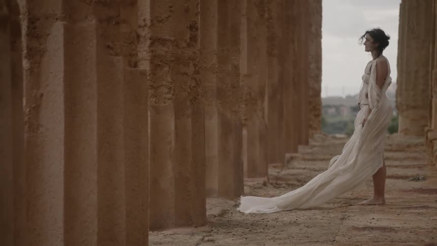 A woman wearing white robes looks ahead