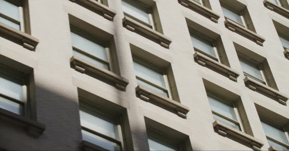 Exterior view of apartment building with windows against the blue sky in the city