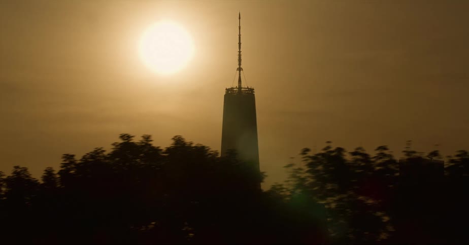 Sun shines above the one world trade center in new york city at evening