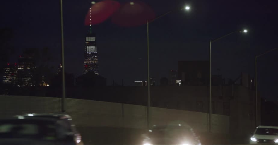 Cars drive at night by the city