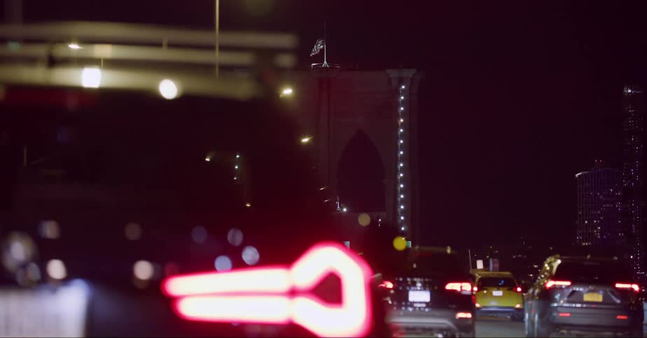 Cars driving on the traffic over the brooklyn bridge in new york city at night