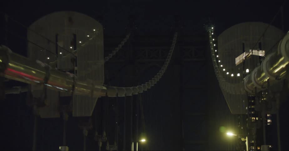 Cars traveling over a large city bridge at night