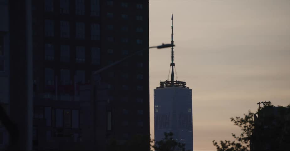 Towering skyscraper with spire at dusk in the city